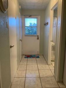 a room with a hallway with a door and a window at Cozy Coastal Beach Retreat in Clearwater Beach