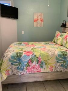 a bed with a colorful comforter in a bedroom at Cozy Coastal Beach Retreat in Clearwater Beach