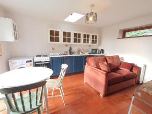 a kitchen with a couch and a table and a chair at Cosy Rural Barn Conversion 5 Min Drive To Pin Mill 1 BR + sofa bed 