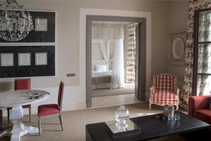 1 dormitorio y sala de estar con mesa y sillas. en Finca Cortesin Hotel Golf & Spa en Casares
