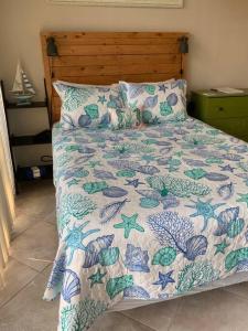 a bed with a blue and white comforter and pillows at Comfy Coastal Beach Vacation in Clearwater Beach