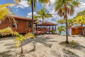 una casa en la playa con palmeras en Anthony's Key Resort, en Sandy Bay