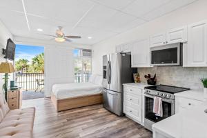 a kitchen with a refrigerator and a bed in a room at Dolphin Watch in Clearwater Beach