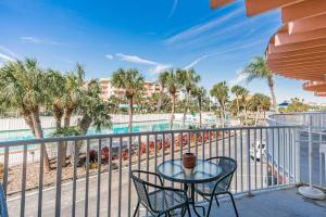 a table and chairs on a balcony with a view of a pool at Dolphin Watch in Clearwater Beach