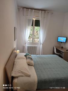 a bedroom with a bed and a desk and a window at Casailaekobe in Bologna