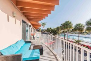 balcón con sofá y piscina en Seaside Serendipity en Clearwater Beach