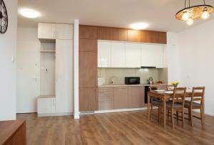 a kitchen with a table and a dining room at Luxus Apartament Rodzinny z sauną i siłownią in Gdańsk