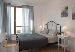 a bedroom with a bed and a large window at Luxus Apartament Rodzinny z sauną i siłownią in Gdańsk