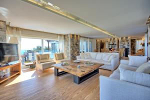 a living room with a couch and a table at Villa Marina by PosarelliVillas in Elounda