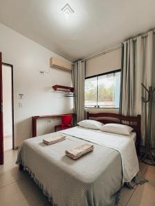 a bedroom with a large bed with two towels on it at Pousada Casa Boa Milagres in Barra do Camaragibe