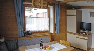 a room with a table with a bottle of wine and fruit on it at Haus Klammtal in Schwendau