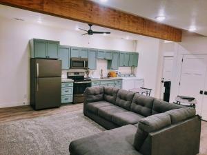 a living room with a couch and a kitchen at Sevier River Farmhouse 1 in Hatch