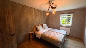 sypialnia z łóżkiem i oknem w obiekcie La ferme du Comte w mieście Durbuy
