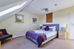 a bedroom with a king sized bed and a chair at 37a Stonegate Loft in York