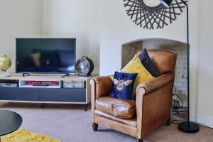 a living room with a chair and a television at 37a Stonegate Loft in York