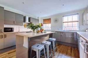a kitchen with a large island with stools at 37a Stonegate Loft in York