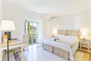 a white bedroom with a bed and a desk at Villa Cielo Blu - Homelike Villas in Montecatini Terme