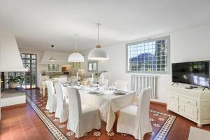 a dining room with a table and white chairs at Villa Cielo Blu - Homelike Villas in Montecatini Terme