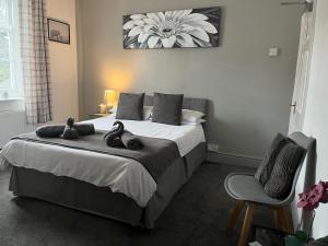 ein Schlafzimmer mit einem Bett mit zwei ausgestopften Tieren darauf in der Unterkunft The Swan Hotel in Kington