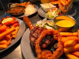 una tavola ricoperta di piatti di cibo con anelli di cipolla e patatine fritte di The Swan Hotel a Kington