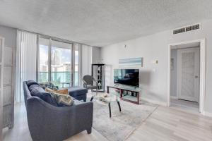 uma sala de estar com um sofá e uma televisão em Great Apartment In Hollywood With Side Ocean View! Direct Access To The Beach! 14th Floor em Hollywood