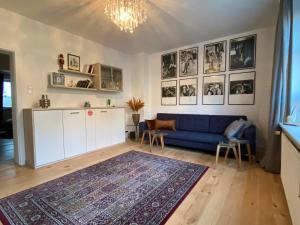 ein Wohnzimmer mit einem blauen Sofa und einem Teppich in der Unterkunft Central City Privatapartment Relax-Inn, Netflix & Sky TV! in Hannover
