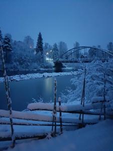 un pont sur une rivière recouverte de neige dans l'établissement Ammeråns Fiskecamp, à Hammarstrand