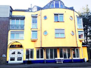 ein gelbes Gebäude mit einem runden Dach in der Unterkunft Hotel Georg in Witten