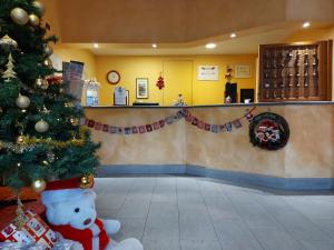 a christmas tree in a lobby with a christmas decoration at Hotel Sommeiller in Bardonecchia