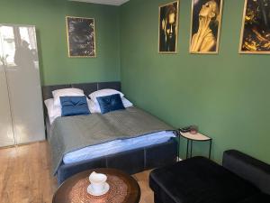 sypialnia z łóżkiem z niebieskimi poduszkami i stołem w obiekcie Apartament Błogi Sen- komfortowy nocleg w sercu Bytomia w Bytomiu