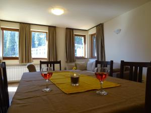 a dining room table with two wine glasses on it at APARTMENT Darsi in Pamporovo