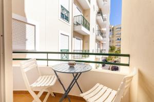 阿爾馬桑－德佩拉的住宿－A54 - Pérola Apartment in Armação de Pêra，阳台配有一张小桌子和两把椅子