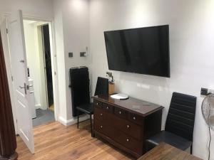 a living room with a flat screen tv on a wall at Hot Tub Hide Away near Alton Towers staffordshire in Cheddleton