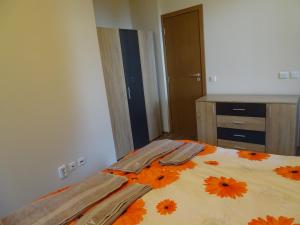 a bedroom with a bed with orange flowers on it at APARTMENT Darsi in Pamporovo