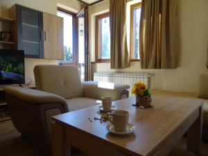 a living room with a wooden table with cups on it at APARTMENT Darsi in Pamporovo