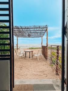 a view of a table and chairs on the beach at Pousada Casa Boa Milagres in Barra do Camaragibe