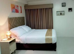 ein Schlafzimmer mit einem Bett und einem Nachttisch mit einer Lampe in der Unterkunft Stunning Studio Type - 1641 - 16th Flr Persimmon in Cebu City