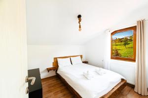 a bedroom with a bed and a window at Le Chalet M - Cabană cu o panoramă de poveste. in Şurdeşti