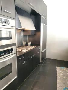 cocina con electrodomésticos de acero inoxidable y fogones en Beach Street Loft en Boston