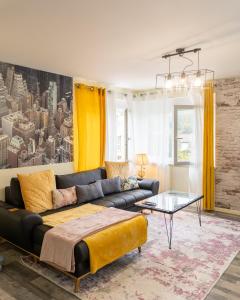 uma sala de estar com um sofá e uma mesa em Lodgespa : Maison Rose em Hésingue