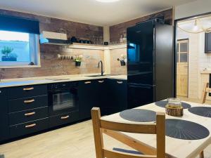 eine Küche mit einem schwarzen Kühlschrank und einem Tisch in der Unterkunft Apartmán Kunst in Kořenov