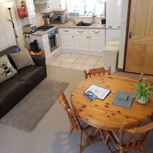 a living room with a wooden table and a couch at The Beehive - Self catering in the heart of the Forest of Dean in Whitecroft