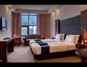 a hotel room with a large bed and a chair at Torino Hotel Amman in Amman