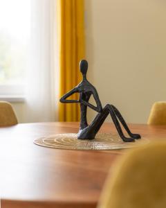 une figurine d'une personne assise sur une table dans l'établissement Lodgespa : Maison Rose, à Hésingue