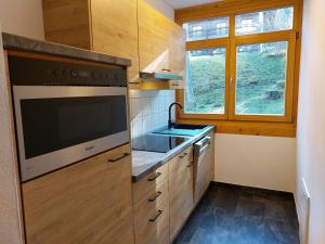 a kitchen with a stove and a sink and a window at Bad Kleinkirchheim RMG family apartments in Bad Kleinkirchheim