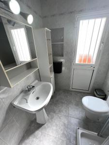 La salle de bains blanche est pourvue d'un lavabo et de toilettes. dans l'établissement Casa Playa Torrecilla, à Nerja