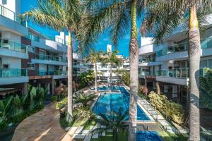 an aerial view of the courtyard of a resort with palm trees at Boulevard 308B - Excelente cobertura em condomínio de luxo no centro de Bombinhas - Piscina - Jacuzzi - Academia - Portaria 24h - (Consultar serviços de roupa de cama e banho) in Bombinhas