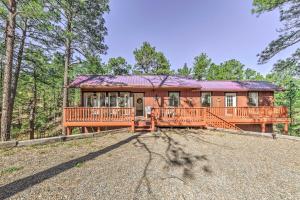 a large house with a large deck in the woods at Dog-Friendly Alto Escape with Hot Tub and Foosball! in Alto