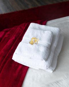 - une serviette blanche avec un emblème doré sur un lit dans l'établissement Suite Romantique, à Hésingue