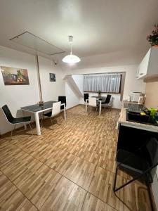 ein Wohnzimmer mit einem Tisch und Stühlen sowie eine Küche in der Unterkunft Apartamenty Ostrowiec - Pokoje Gościnne Centrum in Ostrowiec Świętokrzyski
